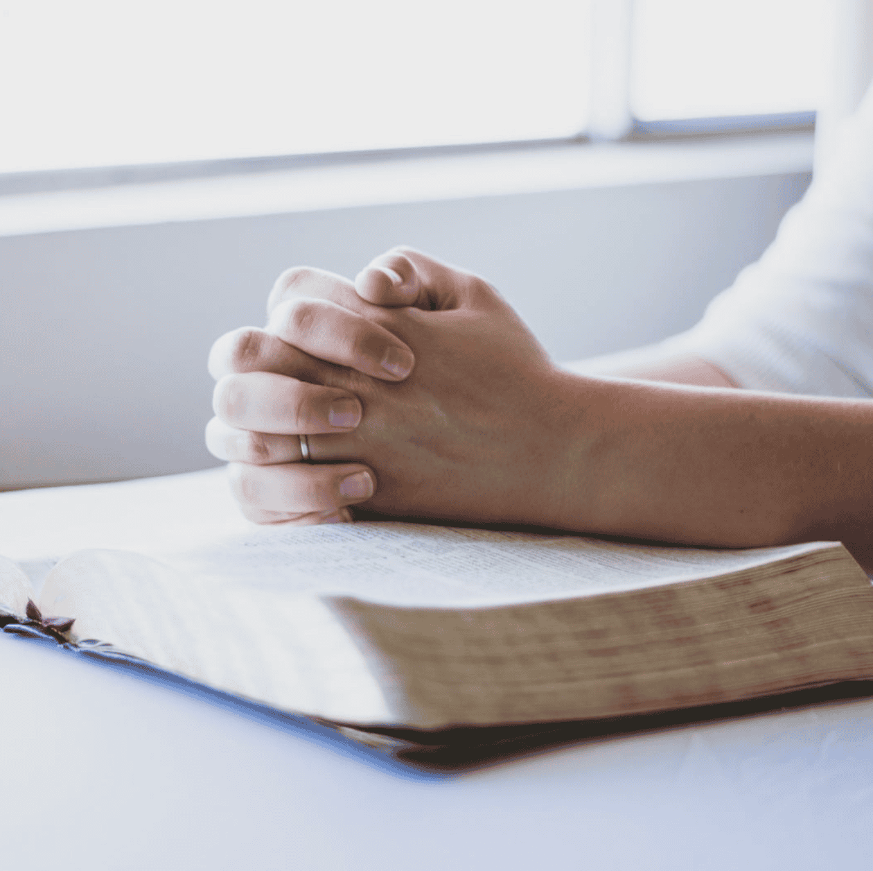 Praying hands on Bible Praying hands on Bible
